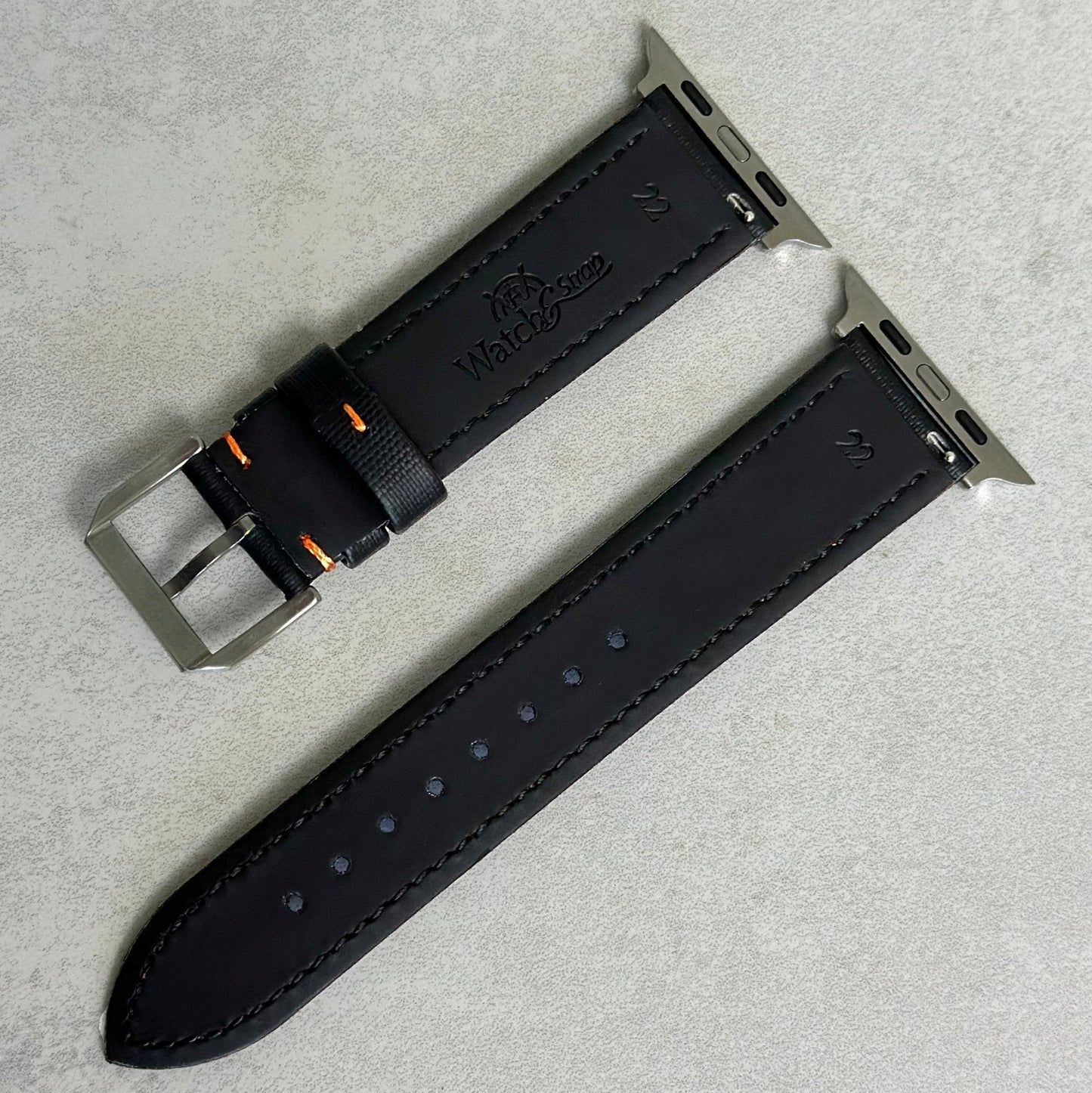 Rear of the Bermuda jet black sail cloth Apple Watch strap with orange stitching. Watch And Strap logo.