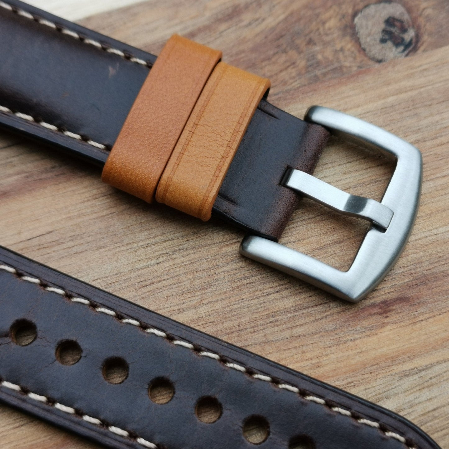 Brushed 316L stainless steel buckle. Grain of the calf leather is visible along with the tan loops.